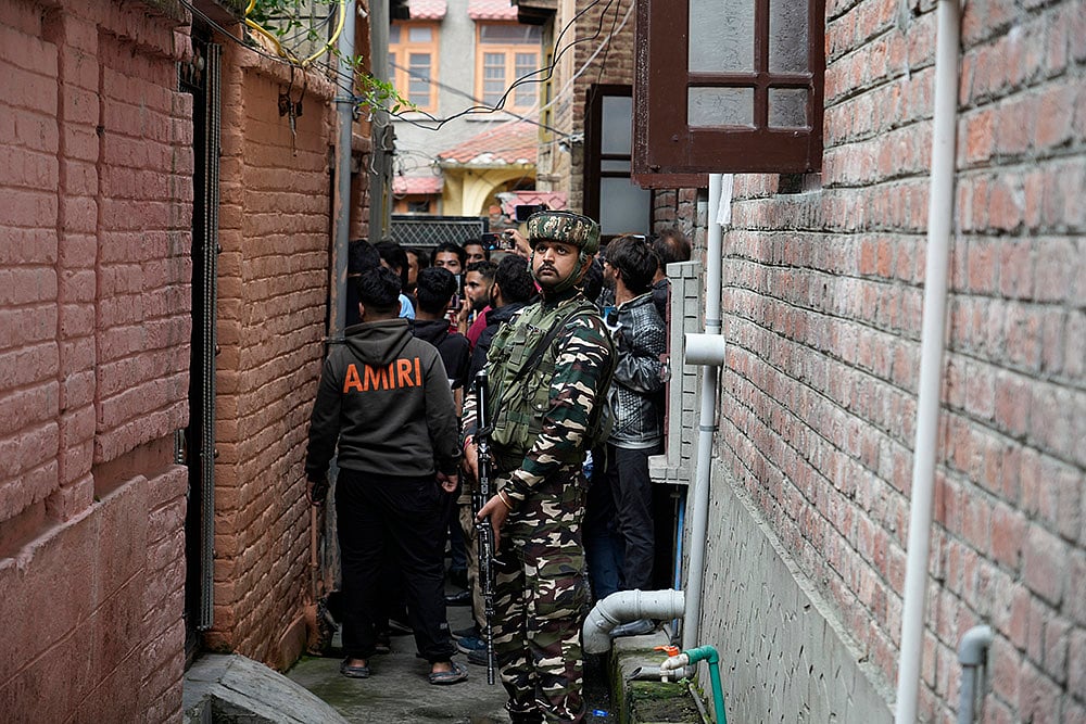 | Photo: AP/Mukhtar Khan : 2024 J&K Elections: An Indian paramilitary soldier guard inside a alley during the door-to-door election campaigning by BJP candidate